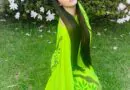 Nãwã Ēma, com vestido e acessório de flor Shavorã.  Vestido verde pintado à mã…